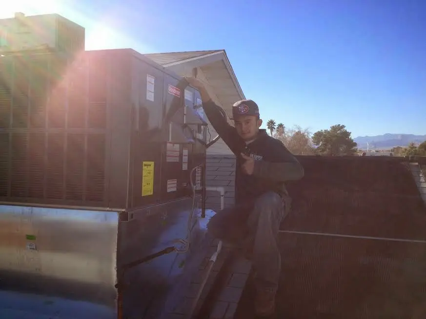 HVAC technician performing HVAC Inspection on a rooftop unit in Massac